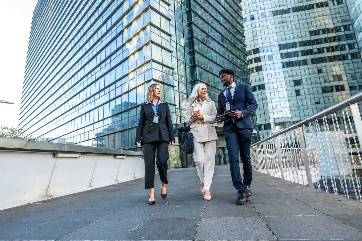 Diverse adults walking together through a modern city during daytime